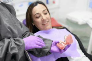 רופא מציג למטופלת שיניים לפני השתלה